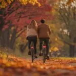 Couple Cycling Through Autumn Leaves Path Fun