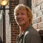Man Leaning Against Brick Wall in Alleyway