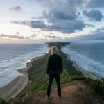 Man Standing on a Cliff Overlooking the Ocean