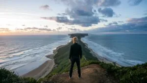 Man Standing on a Cliff Overlooking the Ocean