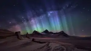 Blue Aurora Above Dark Mountain Peaks