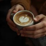 Close-Up of Hands Holding a Coffee Cup Together