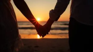 Couple Holding Hands at Sunset Beach