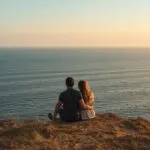 Couple Sitting Together on a Cliff Overlooking the Sea