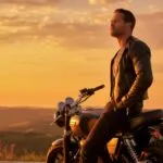 Fit Guy Resting on His Motorcycle at Sunset