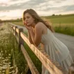 Girl Leaning on Fence by the Countryside