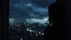 Girl Looking Out at Stormy Night City