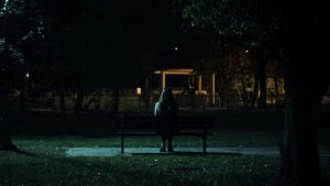 Girl Sitting Alone on Empty Bench at Night