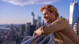 Guy Leaning on Metal Railings Overlooking the City