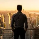 Man Looking Over City Skyline at Sunset