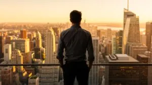 Man Looking Over City Skyline at Sunset