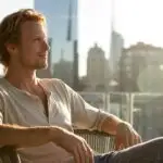 Man Sitting on Balcony Overlooking the City Morning