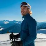 Man Standing on a Snowy Hill With Ski Gear