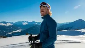 Man Standing on a Snowy Hill With Ski Gear