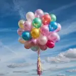 Pastel Balloons Floating in Cloudy Sky