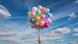 Pastel Balloons Floating in Cloudy Sky