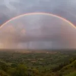 Rainbow Arching Over Valley After Rain