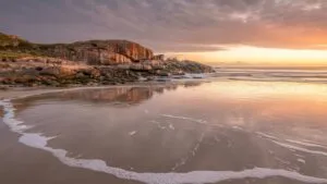 Rocky Beach With Soft Waves at Sunrise