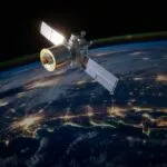 Satellite Orbiting Earth With City Lights Visible