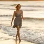 Woman Walking Along Beach With Bare Feet