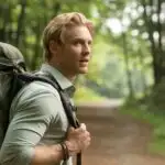 Man Carrying a Backpack Through Forest Trail