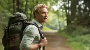 Man Carrying a Backpack Through Forest Trail