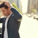 Man Fixing His Hair in Car Side Mirror