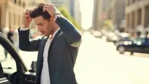 Man Fixing His Hair in Car Side Mirror