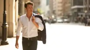 Man Holding Jacket Over Shoulder Walking Down Street