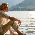 Man Sitting by Lake With Shoes Off Relaxing