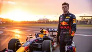 Max Verstappen Standing Beside a Formula One Car at Sunset