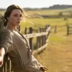 Woman Leaning on Wooden Fence in Countryside