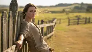 Woman Leaning on Wooden Fence in Countryside
