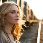 Woman Standing Near Train Tracks at Golden Hour