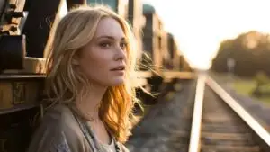Woman Standing Near Train Tracks at Golden Hour