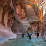 Hikers Walking Through Zion Narrows Canyon River