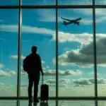 Lone Traveler Watching Airplane Through Airport Window