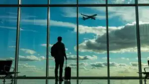 Lone Traveler Watching Airplane Through Airport Window