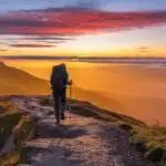 Solo Hiker Walking Along Mountain Ridge at Sunrise