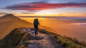 Solo Hiker Walking Along Mountain Ridge at Sunrise