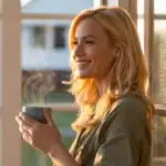 Woman Holding Coffee Cup by Window