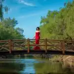 Woman Standing on Wide Wooden Bridge Over River