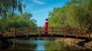 Woman Standing on Wide Wooden Bridge Over River