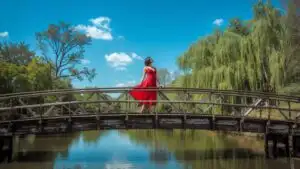 Woman Walking Across Wooden Bridge in Natural Setting