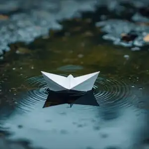 Paper Boat Floating in Rain Puddle