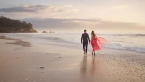 Couple Walking Barefoot on the Beach
