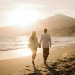 Couple Walking on the Beach at Sunrise