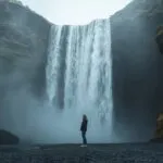 Girl Standing Near Waterfall Mist