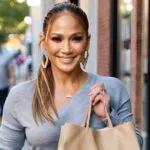 Jennifer Lopez Smiling While Holding a Bookstore Bag