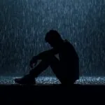 Lonely Silhouette Man Sitting in Rain
